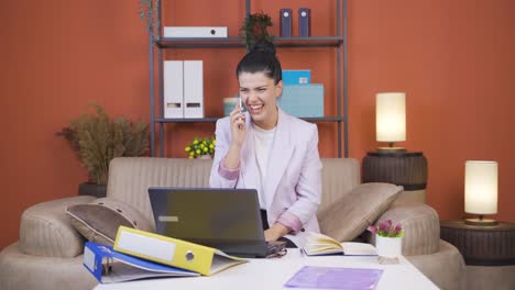 Home-office-worker-young-woman-getting-good-news-on-the-phone.